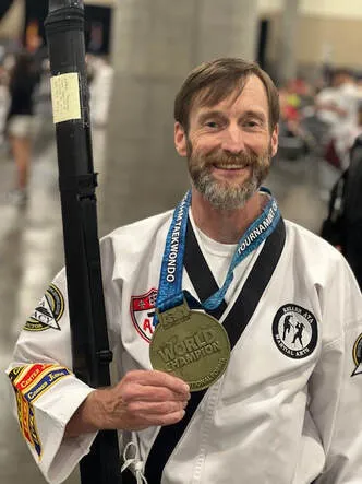 Instructor proudly showing a tournament medal