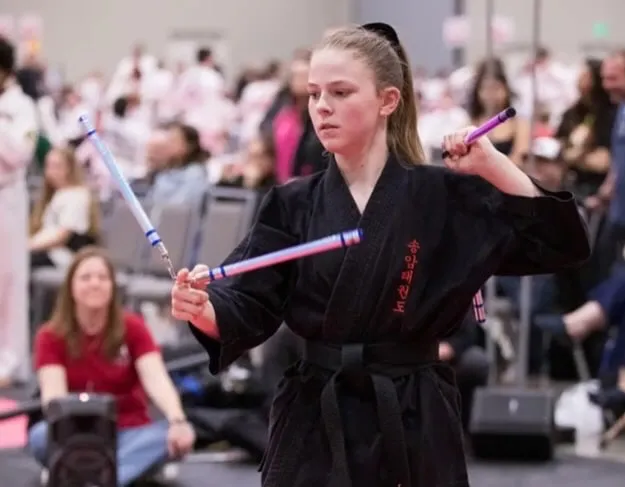 Student performing with a weapon at a tournament